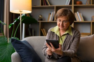 Kvisse sitter i sofaen og ser på mobilen sin.